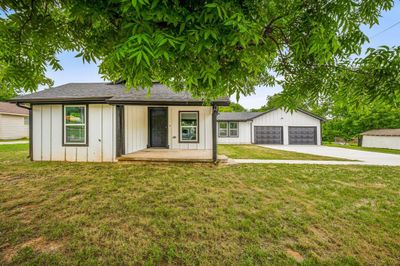 View of front facade with an outdoor structure, a front yard, and a garage | Image 2