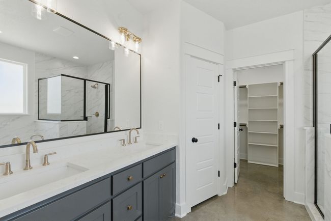 Full bathroom with a marble finish shower, double vanity, concrete flooring, and a spacious closet | Image 13