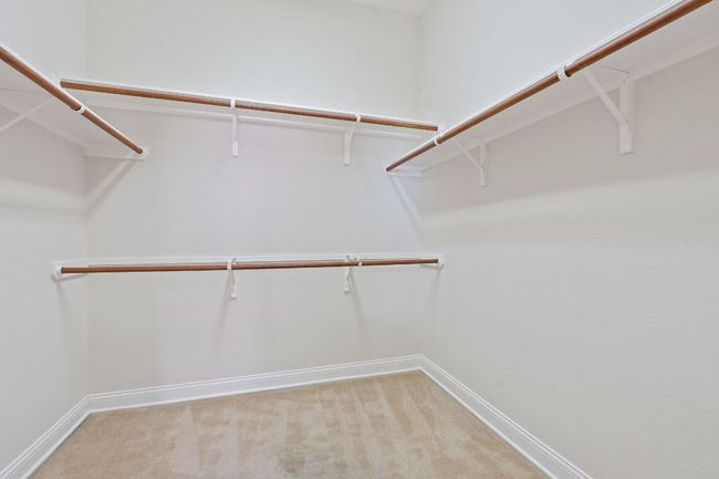 Walk in closet featuring light colored carpet | Image 25
