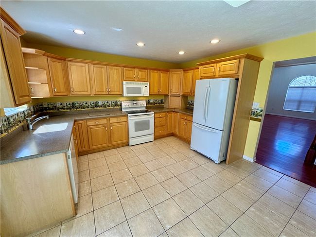 Kitchen features recessed lighting along with solid surface countertops. | Image 9