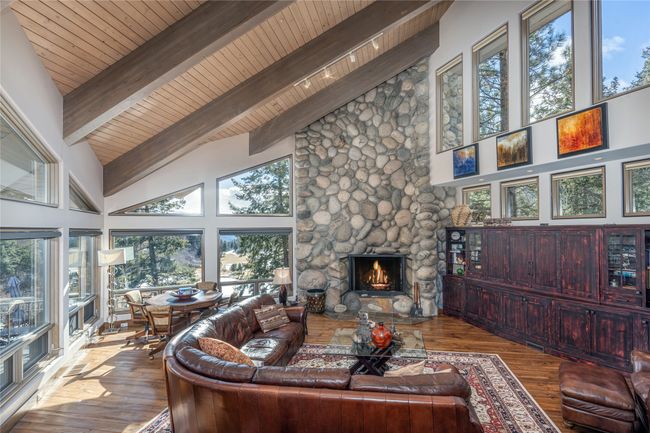 Living room with a fireplace, beam ceiling, wood-type flooring, high vaulted ceiling, and wooden ceiling | Image 11