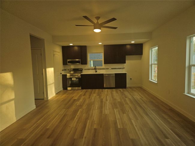Kitchen featuring ceiling fan, baseboards, light countertops, wood finished floors, and stainless steel appliances | Image 4