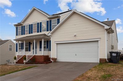 View of front of property featuring a garage and covered porch | Image 1