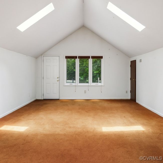 Additional living space with a skylight, carpet, and lofted ceiling | Image 25