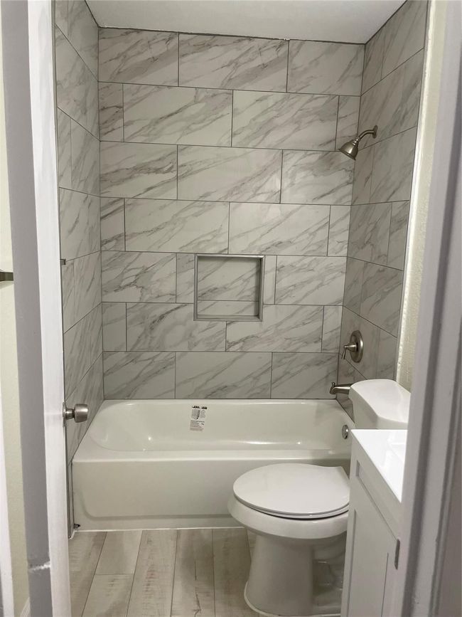 Bathroom with toilet, vanity, and washtub / shower combination | Image 7