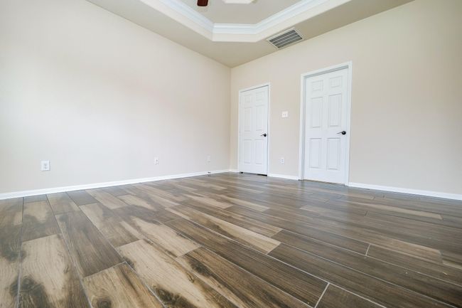 Incredible wall and floor space is embraced by the intimacy of a tray ceiling in the primary suite. | Image 13