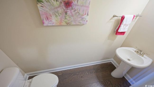 Bathroom with baseboards, toilet, a sink, and wood finished floors | Image 28