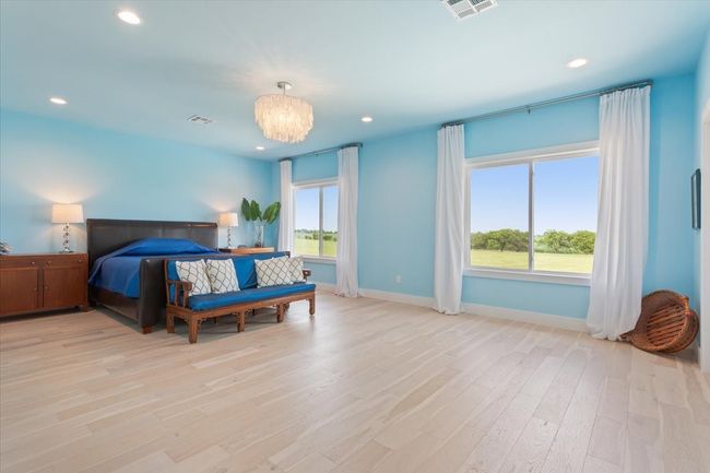 Bedroom with baseboards, light wood-type flooring, recessed lighting, and a chandelier | Image 23