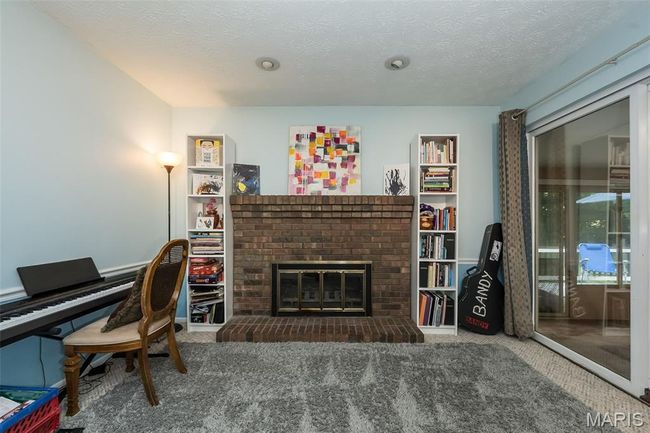Office featuring carpet floors, a brick fireplace, and a textured ceiling | Image 15