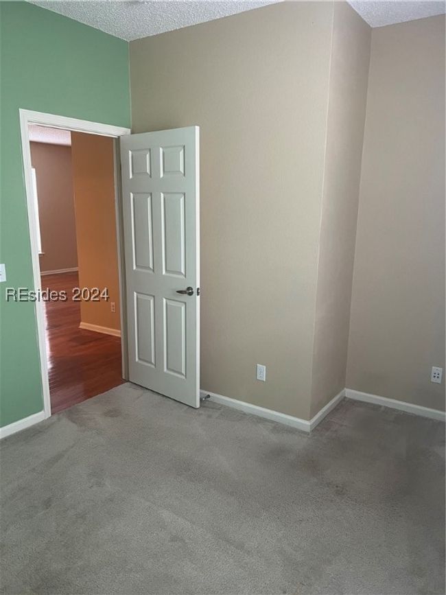 Unfurnished bedroom featuring a textured ceiling and carpet flooring | Image 22