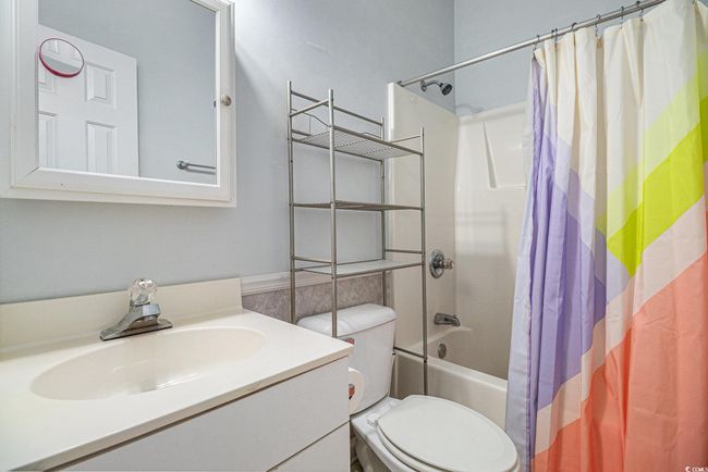 Bathroom featuring shower / bathtub combination with curtain and vanity | Image 14