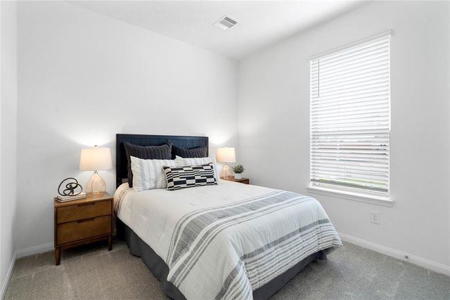 Secondary bedroom features plush carpet, neutral paint, lighting, large window with privacy blinds and ample sized closet space. | Image 5
