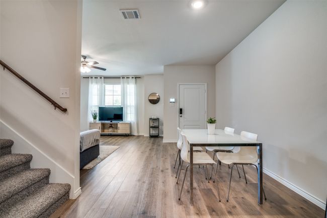 Dining area with stairway, ceiling fan, and light wood finished floors | Image 8