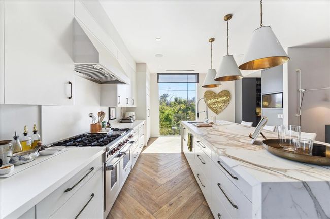 With so much counter space, meal prep is truly a breeze! By now, you’ve probably noticed the strategically placed custom RAM windows throughout—flooding the kitchen with natural light you’ll rarely need to flip a switch. Thoughtful details like soft-close drawers, two built-in trash stations, and dual sinks make this kitchen as functional as it is beautiful. | Image 11