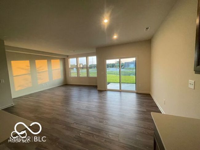 unfurnished living room featuring recessed lighting, dark wood-style flooring, baseboards, and visible vents | Image 10