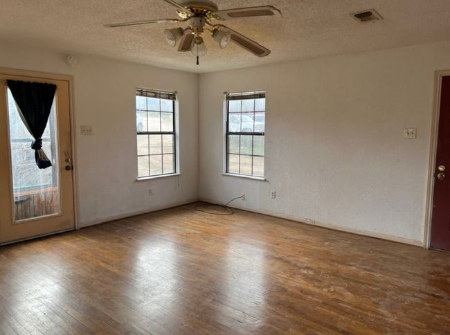 Unfurnished room featuring hardwood / wood-style flooring, ceiling fan, a textured ceiling, and baseboards | Image 5