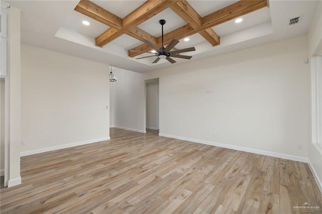 Spare room featuring a ceiling fan, coffered ceiling, recessed lighting, beamed ceiling, and light wood-style floors | Image 4