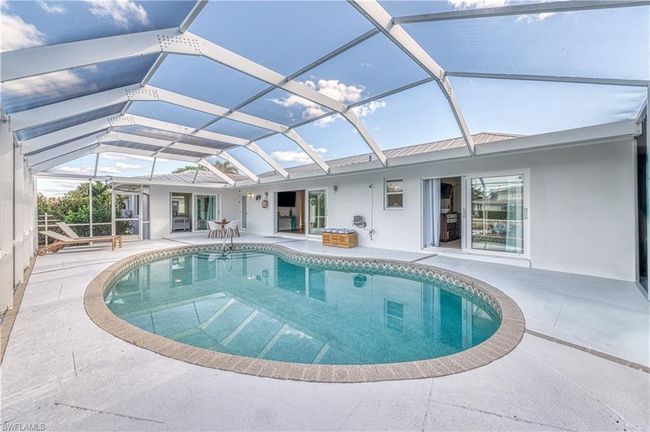 Pool featuring glass enclosure and a patio | Image 5