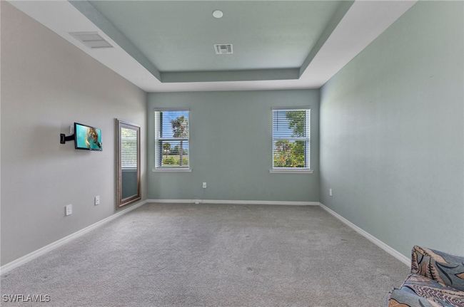 Carpeted Master Bedroom featuring a raised ceiling, baseboards, and visible vents | Image 34