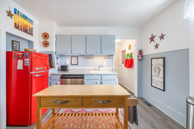 Kitchen featuring dishwasher, a sink, wood finished floors, freestanding refrigerator, and light countertops | Image 21