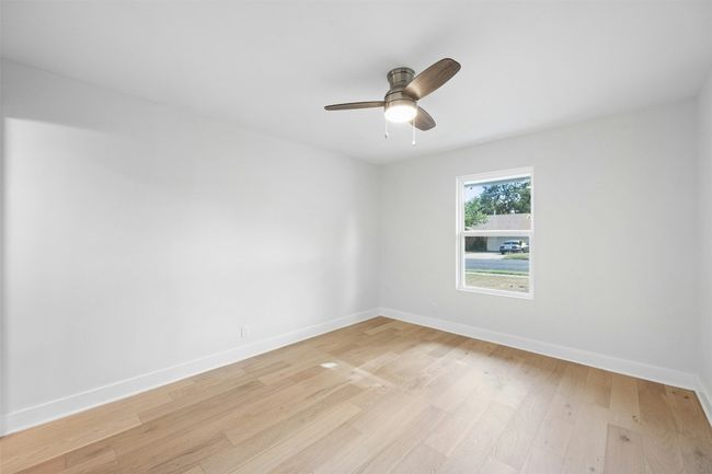 Spare room featuring light wood-style flooring and ceiling fan | Image 30
