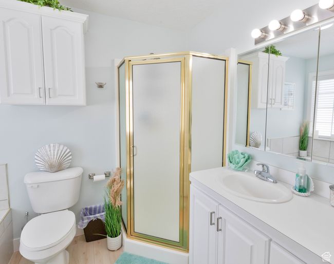 Full bath with vanity, a shower stall, toilet, and wood finished floors | Image 17