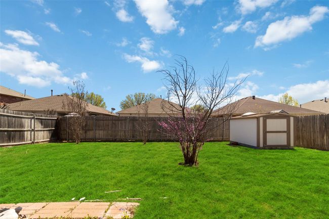 View of yard featuring an outbuilding, a storage shed, and a fenced backyard | Image 25