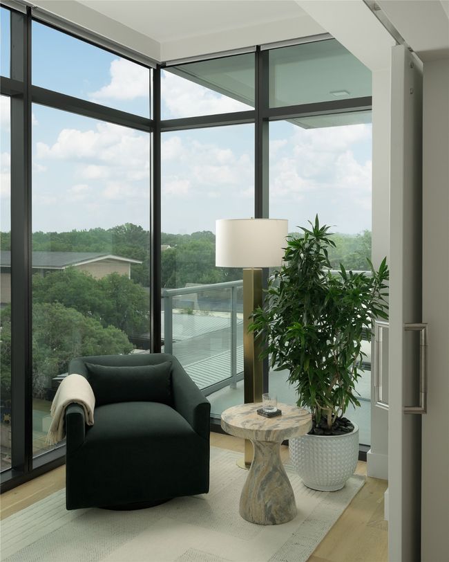 Sitting room featuring expansive windows, wood finished floors, and a water view | Image 18