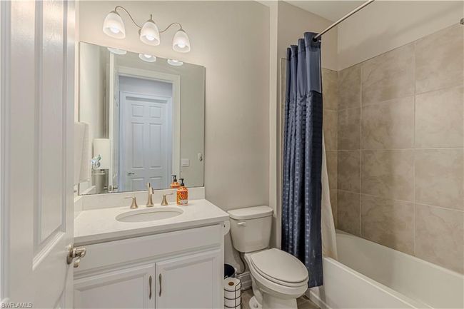 Bathroom with toilet, shower / bath combo with shower curtain, and vanity | Image 16
