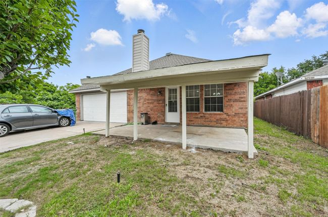 View of front facade with a garage, brick siding, driveway, a chimney, and a shingled roof | Image 28