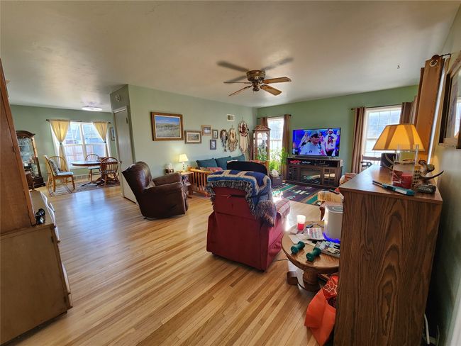 Living area with a wealth of natural light, light wood-type flooring, and ceiling fan | Image 15