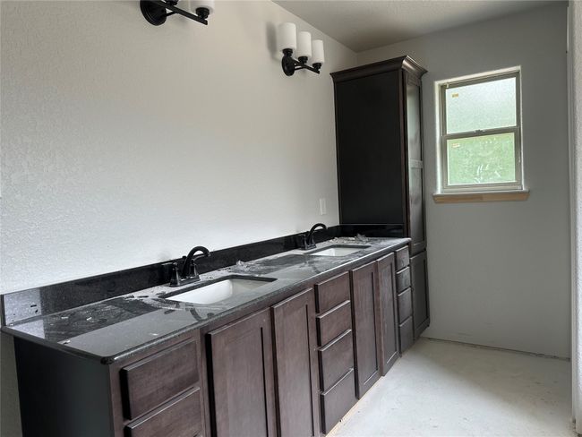 Bathroom featuring a sink, double vanity, and concrete floors | Image 15