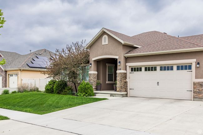 View of front of house with stone siding, stucco siding, an attached garage, driveway, and a shingled roof | Image 42