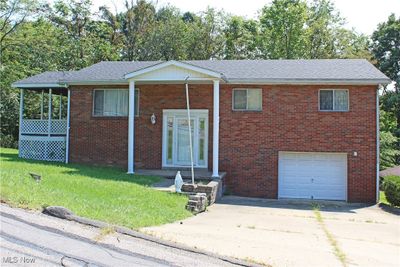 View of front of house with a garage and a front lawn | Image 1