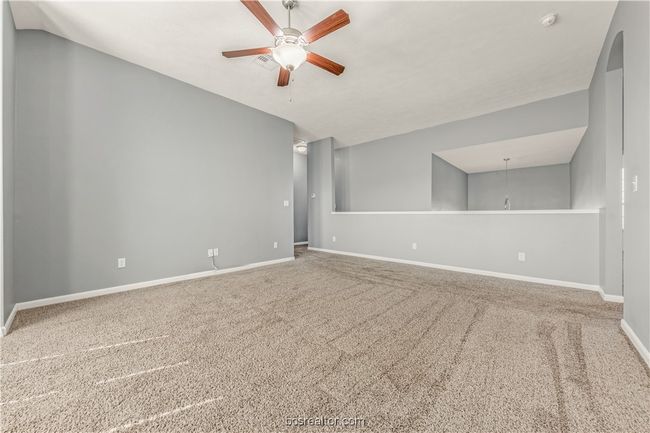 Carpeted empty room featuring lofted ceiling and ceiling fan | Image 18