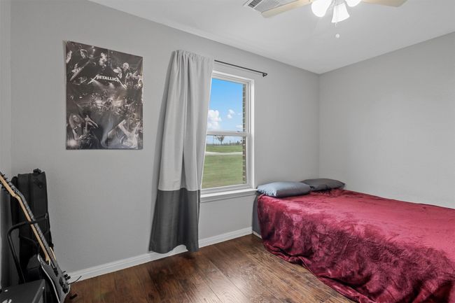 Bedroom with baseboards, ceiling fan, and wood finished floors | Image 29