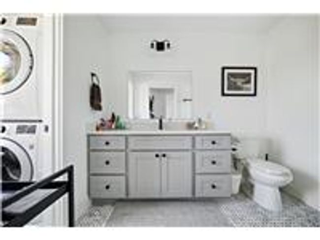 2nd floor bathroom with vanity, and laundry room with stacked washer / dryer | Image 22
