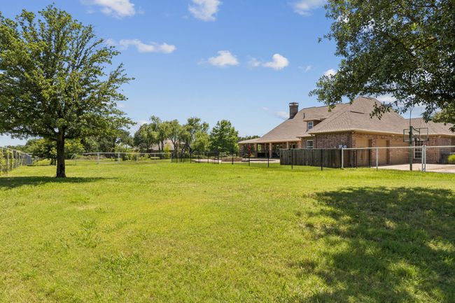 View looking across the back of the property toward the pool area and 3 car garage. This portion of the property is fenced separately and perfect for pets, play toys, options are endless. | Image 4