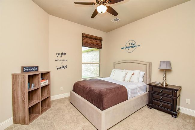The secondary bedroom in the main house has a view of the side yard and breezeway. It also features an ensuite bath. | Image 28