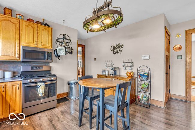 kitchen featuring stainless steel appliances, light wood-style floors, decorative backsplash, and light countertops | Image 23