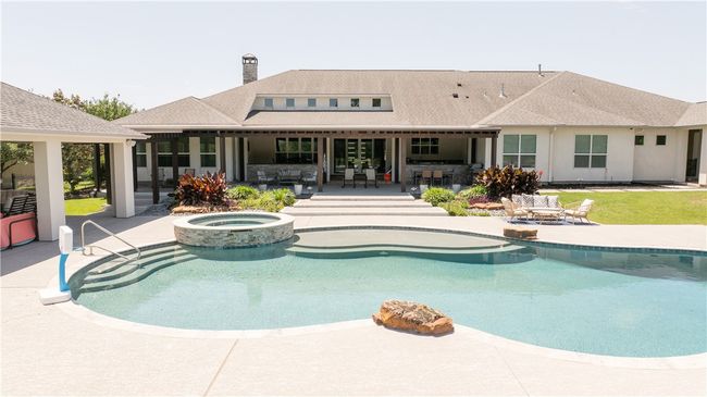 View of swimming pool with a patio area, a pool with connected hot tub, outdoor dining space, and an outdoor living space | Image 15