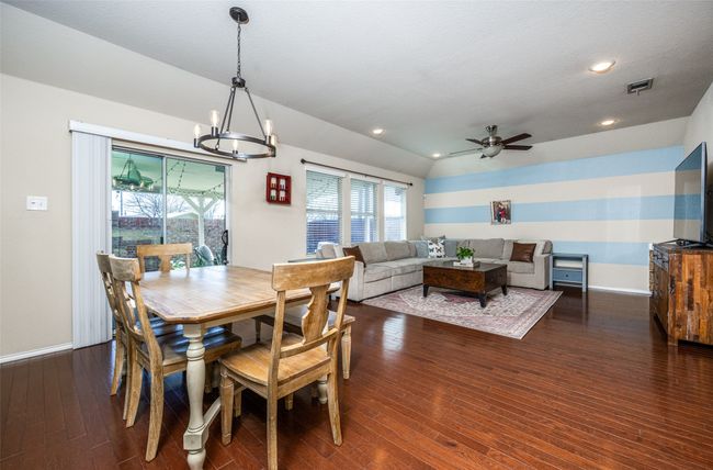 Dining room featuring a chandelier, a ceiling fan, dark wood-type flooring, and recessed lighting | Image 15