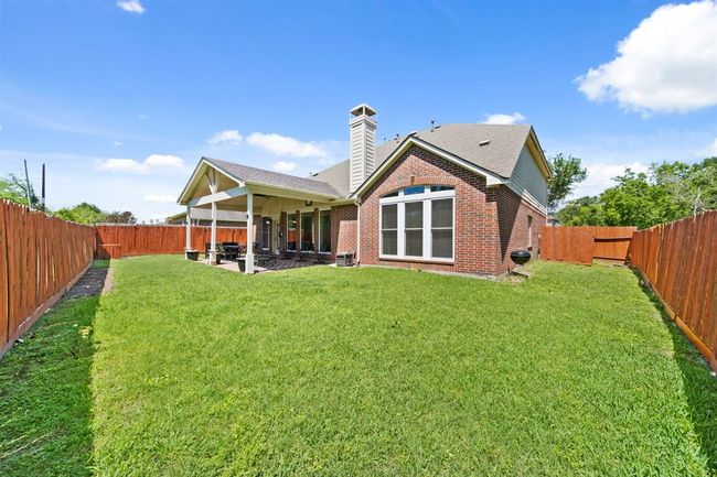With a backdrop of lush trees and ample room to roam, this backyard is the perfect outdoor escape for relaxing or entertaining. | Image 47