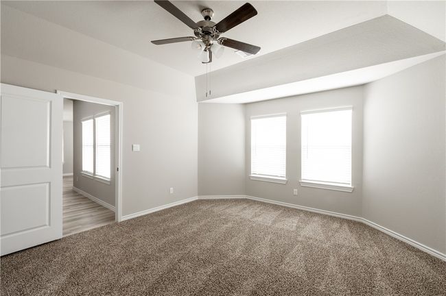 Spare room featuring a ceiling fan, baseboards, and light carpet | Image 11
