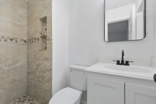 Full bathroom with toilet, vanity, and tiled shower | Image 14