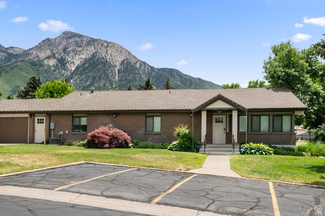 View of front of property featuring a mountain view, brick siding, uncovered parking, and a front yard | Image 35