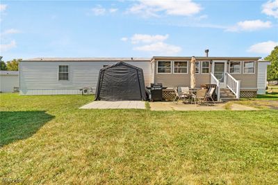 Rear view of house with a lawn and a patio | Image 2