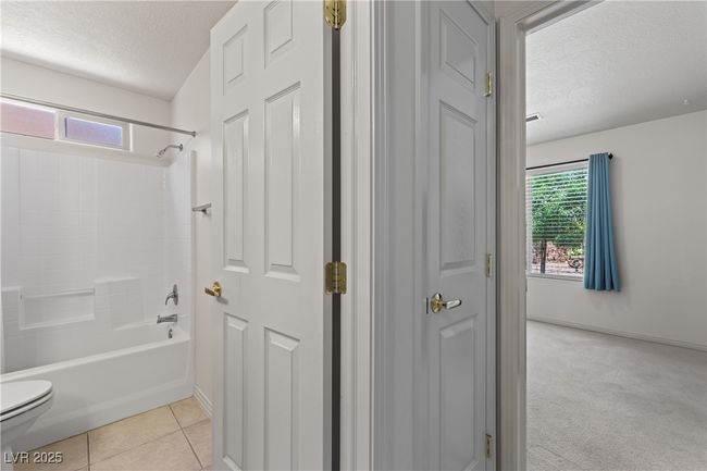 Full bath with a textured ceiling, shower / bathtub combination, and tile patterned floors | Image 29