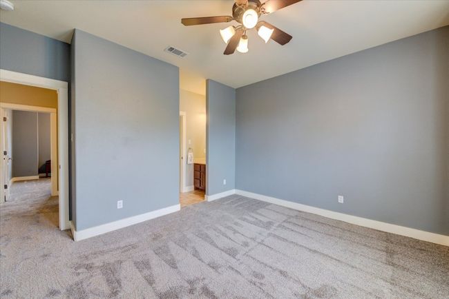 Bedroom featuring walk-in closet, light carpet, and a ceiling fan | Image 30