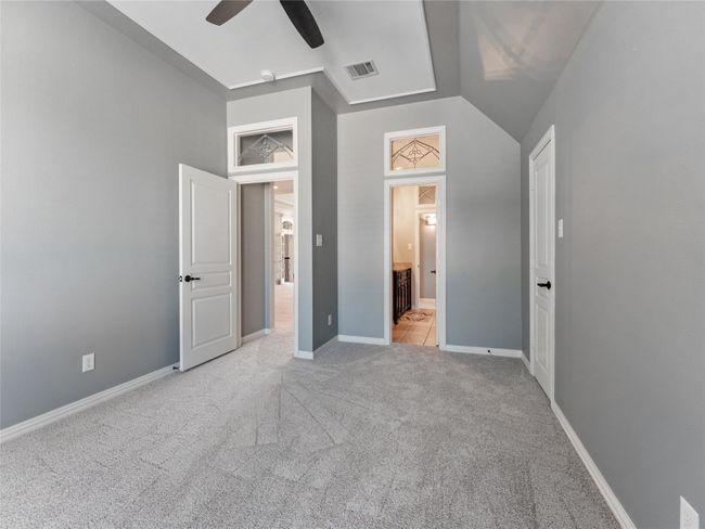 Unfurnished bedroom featuring light carpet, connected bathroom, and a ceiling fan | Image 26